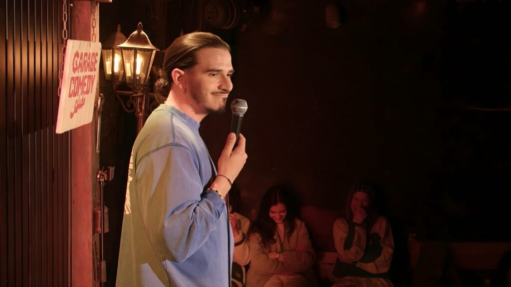 Humoriste au micro sur la scène du Garage Comedy Club, à Marseille